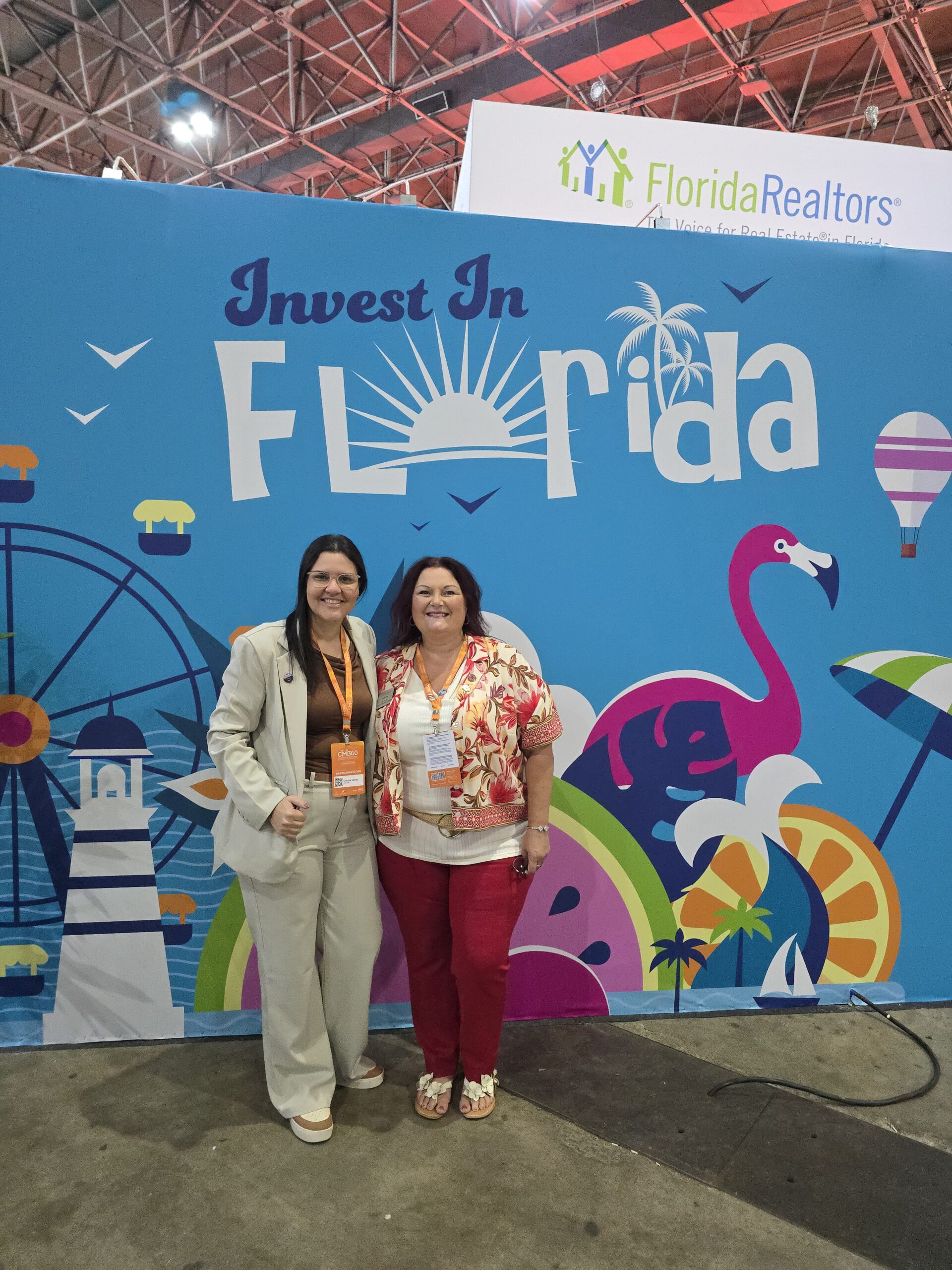 Two real estate professionals standing in front of the Florida Realtors Invest in Florida exhibit at CIMI360.